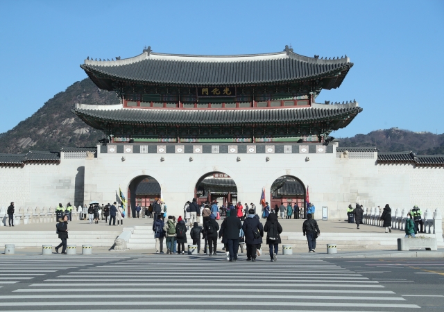 游客在韩国首尔的光化门广场前游览（新华社图）